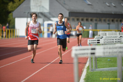 Zwei jugendliche Aktive messen sich Seite an Seite auf der Rundbahn beim Walfried-Heinz-Sportfest der TG Konz im Saar-Mosel-Stadion in Konz.