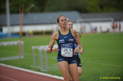 Eine Person in blauem Trikot läuft über die Rundbahn beim Walfried-Heinz-Sportfest der TG Konz im Saar-Mosel-Stadion in Konz.