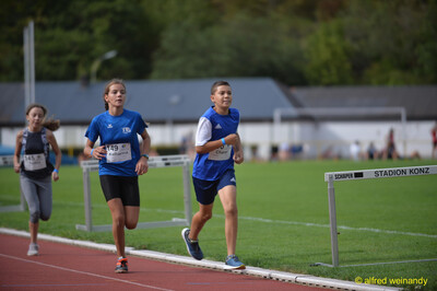 Kinder laufen hintereinander über die Rundbahn beim Walfried-Heinz-Sportfest der TG Konz im Saar-Mosel-Stadion in Konz.