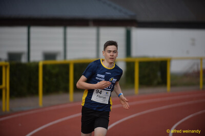 Eine jugendliche Person läuft in der Kurve der Rundbahn beim Walfried-Heinz-Sportfest der TG Konz im Saar-Mosel-Stadion in Konz.