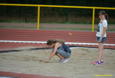 Ein Kind glättet den Sand in der Weitsprunggrube beim Walfried-Heinz-Sportfest der TG Konz im Saar-Mosel-Stadion in Konz.