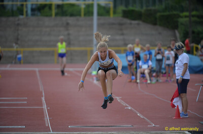 Eine Person schwebt im Weitsprung in der Flugphase über die Anlaufbahn beim Walfried-Heinz-Sportfest der TG Konz im Saar-Mosel-Stadion in Konz.