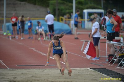 Eine Person landet im Weitsprung mit gestreckten Beinen in der Sandgrube beim Walfried-Heinz-Sportfest der TG Konz im Saar-Mosel-Stadion in Konz.