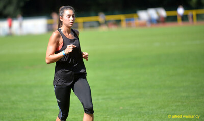 Eine Person joggt zum Aufwärmen locker über den Rasen beim Walfried-Heinz-Sportfest der TG Konz im Saar-Mosel-Stadion in Konz.