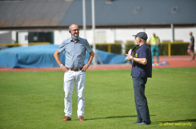 Zwei Offizielle stehen mit Mikrofon auf dem Rasen beim Walfried-Heinz-Sportfest der TG Konz im Saar-Mosel-Stadion in Konz.
