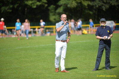 Die Moderation spricht ins Mikrofon im Innenraum beim Walfried-Heinz-Sportfest der TG Konz im Saar-Mosel-Stadion in Konz.