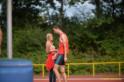Eine Person spricht mit einer betreuenden Person am Rand der Laufbahn beim Walfried-Heinz-Sportfest der TG Konz im Saar-Mosel-Stadion in Konz.