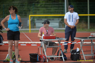 Eine Person im Kampfgericht hält eine Wurfscheibe für den Diskuswurf am Wettkampftisch, beim Walfried-Heinz-Sportfest der TG Konz im Saar-Mosel-Stadion in Konz.