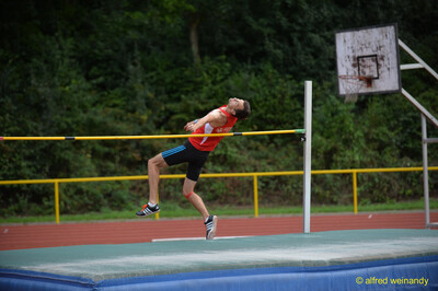 Eine Person streckt sich beim Absprung an der Hochsprunglatte beim Walfried-Heinz-Sportfest der TG Konz im Saar-Mosel-Stadion in Konz.