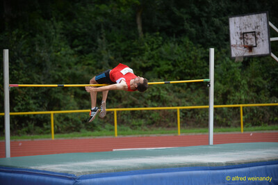 Eine Person überquert die Latte in Fosbury-Flop-Technik beim Walfried-Heinz-Sportfest der TG Konz im Saar-Mosel-Stadion in Konz.