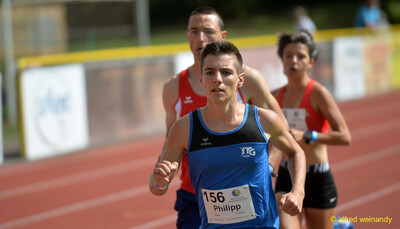 Eine Person setzt sich mit konzentriertem Blick an die Spitze des Feldes auf der Rundbahn, beim Walfried-Heinz-Sportfest der TG Konz im Saar-Mosel-Stadion in Konz.
