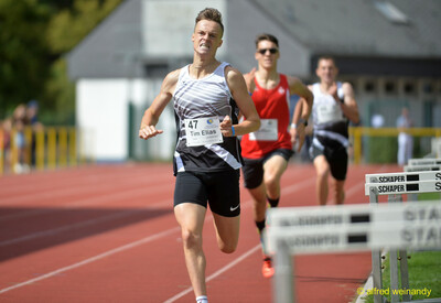 Eine angestrengte Person kämpft sich im Zieleinlauf über die Rundbahn, beim Walfried-Heinz-Sportfest der TG Konz im Saar-Mosel-Stadion in Konz.