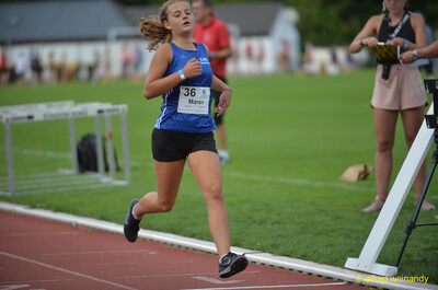 Eine Person läuft in flottem Tempo auf der roten Laufbahn nahe der Ziellinie beim Walfried-Heinz-Sportfest der TG Konz im Saar-Mosel-Stadion in Konz.