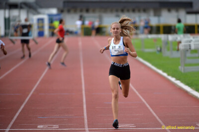 Eine Person sprintet über die Ziellinie auf der Rundbahn beim Walfried-Heinz-Sportfest der TG Konz im Saar-Mosel-Stadion in Konz.