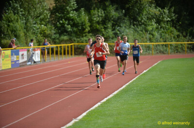 Eine Person führt das Feld auf der Rundbahn an beim Walfried-Heinz-Sportfest der TG Konz im Saar-Mosel-Stadion in Konz.