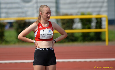Ein Kind steht mit den Händen in den Hüften an der Laufbahn beim Walfried-Heinz-Sportfest der TG Konz im Saar-Mosel-Stadion in Konz.