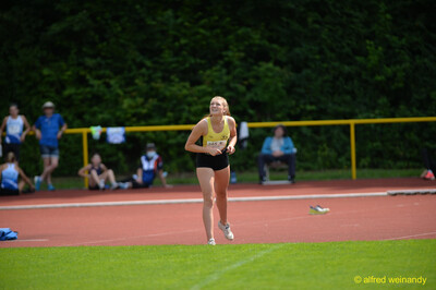 Eine Person joggt am Rand des Rasens und blickt nach oben, beim Walfried-Heinz-Sportfest der TG Konz im Saar-Mosel-Stadion in Konz.
