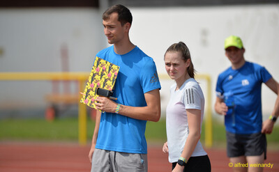 Eine Person im Helferdienst und eine aktive Person stehen mit Klemmbrett auf der Laufbahn beim Walfried-Heinz-Sportfest der TG Konz im Saar-Mosel-Stadion in Konz.