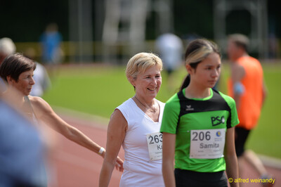 Mehrere Aktive gehen mit Startnummern über die Laufbahn beim Walfried-Heinz-Sportfest der TG Konz im Saar-Mosel-Stadion in Konz.