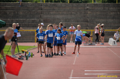 Eine Gruppe von Kindern wartet mit Startnummern am Bahnrand auf ihren Einsatz beim Walfried-Heinz-Sportfest der TG Konz im Saar-Mosel-Stadion in Konz.