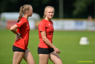 Zwei Jugendliche in roten Trikots stehen auf dem Rasen im Innenraum beim Walfried-Heinz-Sportfest der TG Konz im Saar-Mosel-Stadion in Konz.