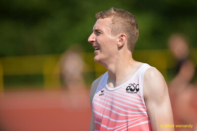 Eine Person mit Kappe und Trillerpfeife beobachtet das Geschehen am Rand des Sportplatzes beim Walfried-Heinz-Sportfest der TG Konz im Saar-Mosel-Stadion in Konz.