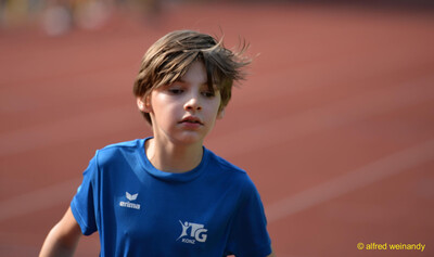 Ein Kind im TG-Konz-Trikot blickt konzentriert auf der Laufbahn beim Walfried-Heinz-Sportfest der TG Konz im Saar-Mosel-Stadion in Konz.