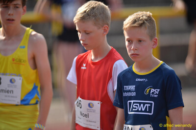 Zwei Kinder mit Startnummern stehen konzentriert nebeneinander und warten beim Walfried-Heinz-Sportfest der TG Konz im Saar-Mosel-Stadion in Konz.