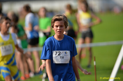 Ein Kind im blauen Shirt steht am Rand der Wettkampfanlage beim Walfried-Heinz-Sportfest der TG Konz im Saar-Mosel-Stadion in Konz.
