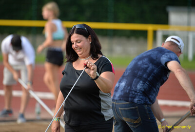 Mehrere Helfende bereiten mit Maßband und Rechen eine Wettkampfanlage vor beim Walfried-Heinz-Sportfest der TG Konz im Saar-Mosel-Stadion in Konz.
