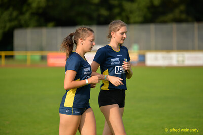 Zwei Jugendliche joggen zum Aufwärmen über den Rasen beim Walfried-Heinz-Sportfest der TG Konz im Saar-Mosel-Stadion in Konz.
