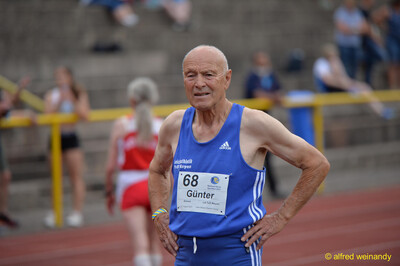 Eine ältere Person im blauen Trikot mit der Startnummer 68 steht auf der Bahn beim Walfried-Heinz-Sportfest der TG Konz im Saar-Mosel-Stadion in Konz.