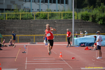 Eine Person setzt zu einem Sprung über die Dreisprunganlage an beim Walfried-Heinz-Sportfest der TG Konz im Saar-Mosel-Stadion in Konz.