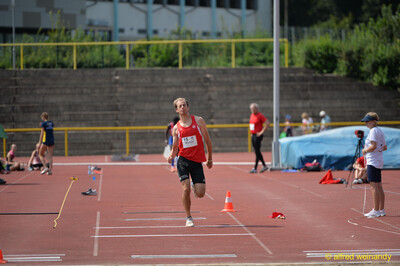 Eine Person zieht in der Sprungphase das Knie hoch über der Dreisprunganlage beim Walfried-Heinz-Sportfest der TG Konz im Saar-Mosel-Stadion in Konz.