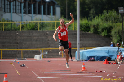 Eine Person befindet sich in der Sprungphase auf der Anlaufbahn beim Walfried-Heinz-Sportfest der TG Konz im Saar-Mosel-Stadion in Konz.