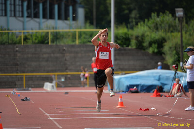 Eine Person zieht in der Sprungphase mit hohem Kniehub das Bein an, beim Walfried-Heinz-Sportfest der TG Konz im Saar-Mosel-Stadion in Konz.