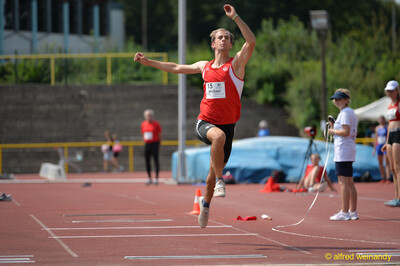 Eine Person fliegt mit angezogenem Bein durch die Sprungphase, beim Walfried-Heinz-Sportfest der TG Konz im Saar-Mosel-Stadion in Konz.