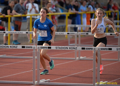Zwei junge Aktive sprinten beim Hürdenlauf zwischen den Hürden auf der Bahn beim Walfried-Heinz-Sportfest der TG Konz im Saar-Mosel-Stadion in Konz.