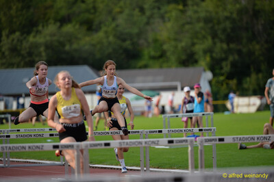 Mehrere junge Aktive überqueren im Hürdenlauf nebeneinander die Hürden beim Walfried-Heinz-Sportfest der TG Konz im Saar-Mosel-Stadion in Konz.