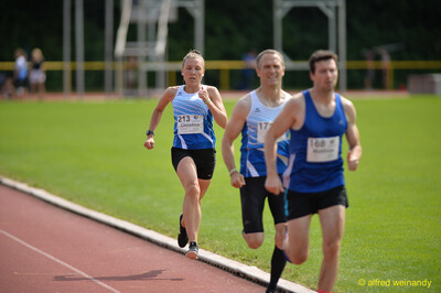 Eine Person führt vor zwei Verfolgenden auf der Rundbahn beim Walfried-Heinz-Sportfest der TG Konz im Saar-Mosel-Stadion in Konz.