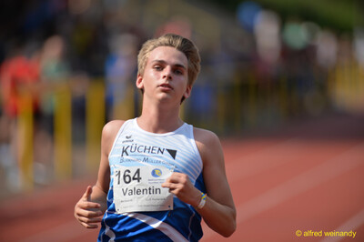 Eine Person läuft mit konzentriertem Blick über die Laufbahn beim Walfried-Heinz-Sportfest der TG Konz im Saar-Mosel-Stadion in Konz.