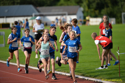 Eine Gruppe von Kindern läuft dicht beieinander auf der Rundbahn beim Walfried-Heinz-Sportfest der TG Konz im Saar-Mosel-Stadion in Konz.