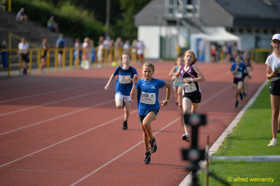 Eine führende Person zieht auf der Rundbahn vor dem verteilten Feld davon beim Walfried-Heinz-Sportfest der TG Konz im Saar-Mosel-Stadion in Konz.