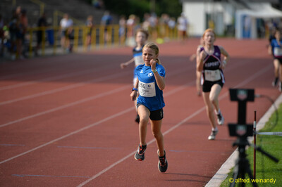 Ein Kind läuft mit entschlossenem Blick auf der Rundbahn beim Walfried-Heinz-Sportfest der TG Konz im Saar-Mosel-Stadion in Konz.
