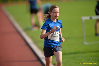 Ein Kind im blauen TG-Konz-Trikot läuft auf der Laufbahn beim Walfried-Heinz-Sportfest der TG Konz im Saar-Mosel-Stadion in Konz.