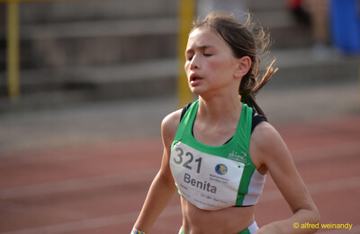 Ein Kind läuft mit geschlossenen Augen angestrengt über die Laufbahn beim Walfried-Heinz-Sportfest der TG Konz im Saar-Mosel-Stadion in Konz.