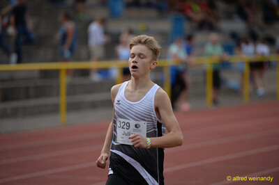 Eine jugendliche Person läuft sichtlich angestrengt auf der Laufbahn beim Walfried-Heinz-Sportfest der TG Konz im Saar-Mosel-Stadion in Konz.