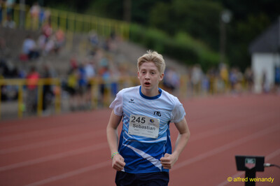 Eine jugendliche Person läuft konzentriert über die Rundbahn beim Walfried-Heinz-Sportfest der TG Konz im Saar-Mosel-Stadion in Konz.