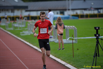Eine Person nähert sich mit angestrengtem Gesicht dem Zielband beim Walfried-Heinz-Sportfest der TG Konz im Saar-Mosel-Stadion in Konz.