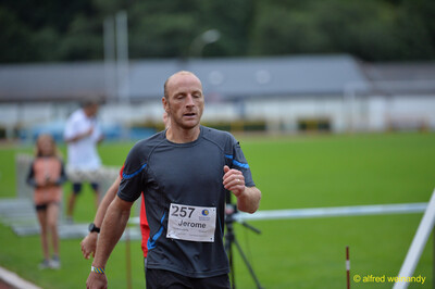 Eine erschöpfte Person läuft nach dem Zieleinlauf auf der Bahn aus beim Walfried-Heinz-Sportfest der TG Konz im Saar-Mosel-Stadion in Konz.